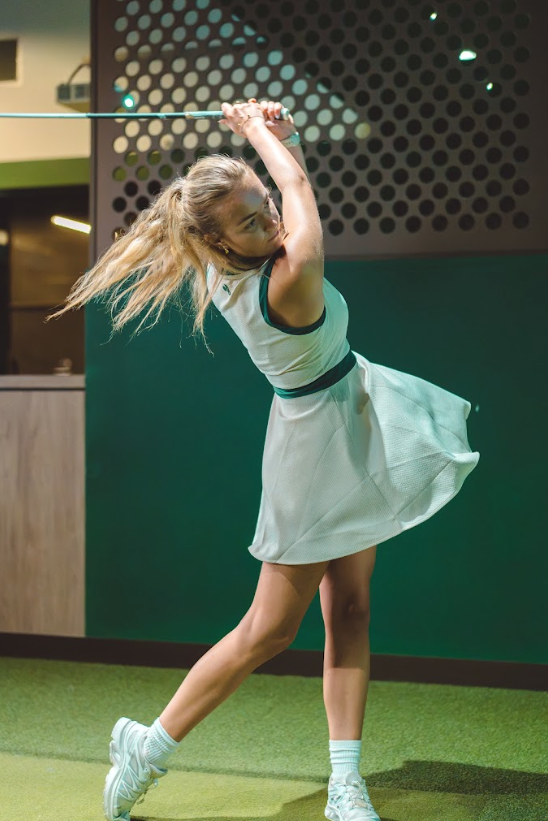 A woman mid-swing at GolfSpace.